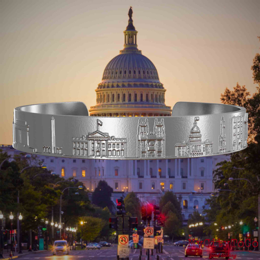 Armreif aus Edelstahl mit Reliefs bekannter Sehenswürdigkeiten der Stadt Washington. Den Hintergrund bildet eine Ansicht der Stadt Washington.