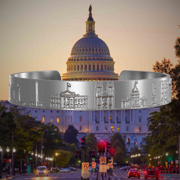 Armreif aus Edelstahl mit Reliefs bekannter Sehenswürdigkeiten der Stadt Washington. Den Hintergrund bildet eine Ansicht der Stadt Washington.