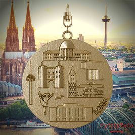 Halskette mit Drehwirbel und Rückseite eines Schmuckanhängers aus vergoldetem Edelstahl, auf dem Reliefs bekannter Sehenswürdigkeiten der Stadt Koeln abgebildet sind. Den Hintergrund bildet eine Ansicht der Stadt Koeln.