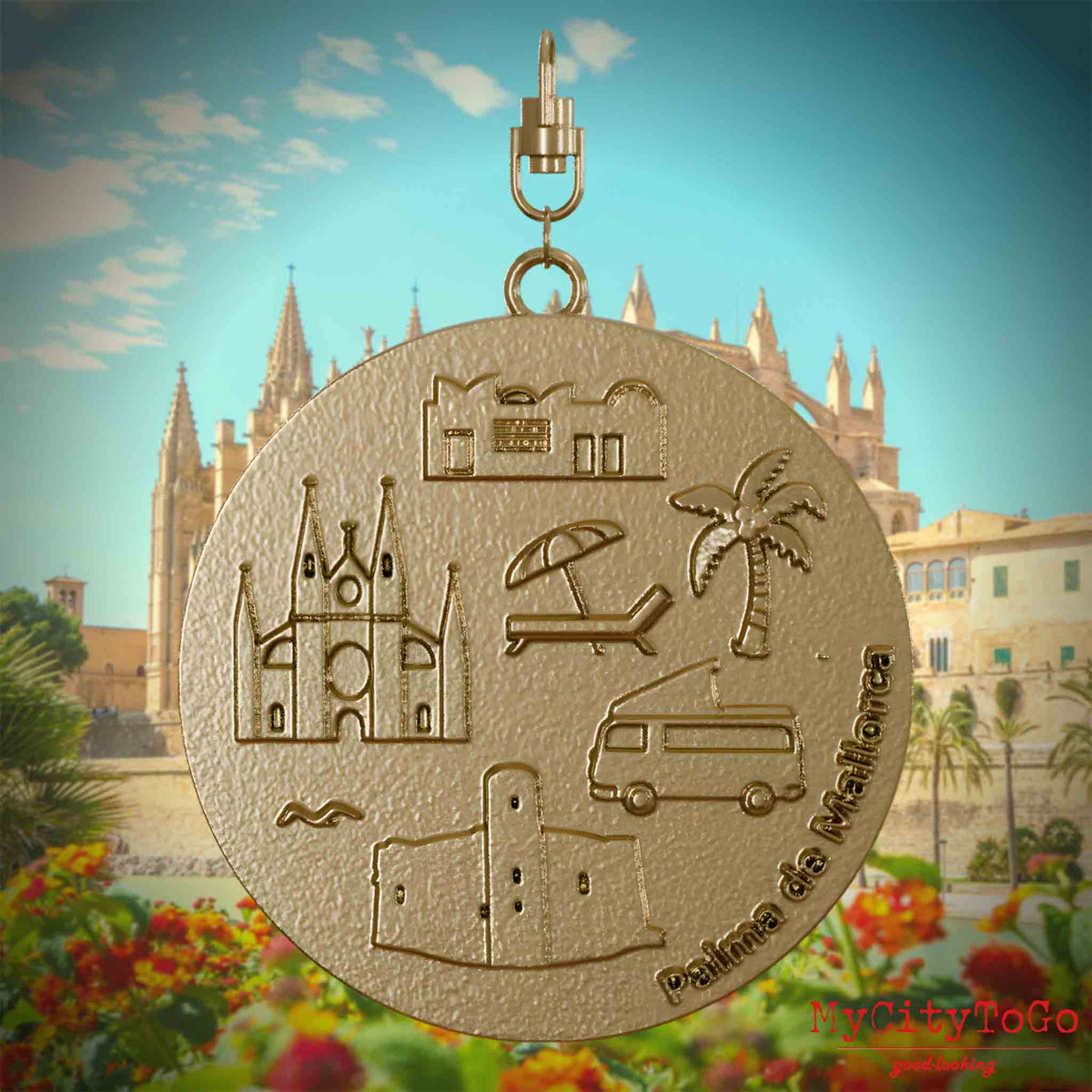 Halskette mit Drehwirbel und Rückseite eines Schmuckanhängers aus vergoldetem Edelstahl, auf dem Reliefs bekannter Sehenswürdigkeiten der Stadt Palma de Mallorca abgebildet sind. Den Hintergrund bildet eine Ansicht der Stadt Palma de Mallorca.
