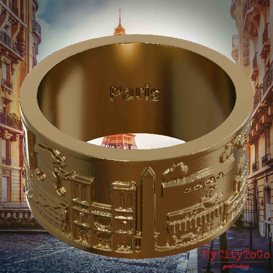 Ring aus vergoldetem Edelstahl mit Reliefs bekannter Sehenswürdigkeiten der Stadt Paris und einer Gravur des Stadtnamens auf der Innenseite. Den Hintergrund bildet eine Ansicht der Stadt Paris.