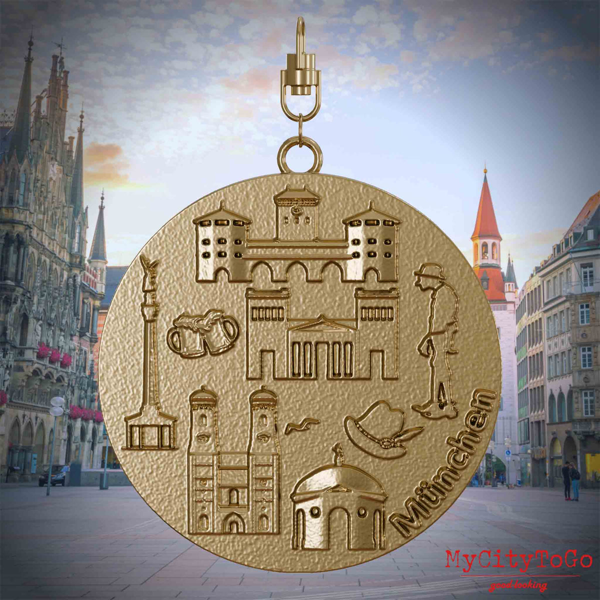 Halskette mit Drehwirbel und Vorderseite eines Schmuckanhängers aus vergoldetem Edelstahl, auf dem Reliefs bekannter Sehenswürdigkeiten der Stadt Muenchen abgebildet sind. Den Hintergrund bildet eine Ansicht der Stadt Muenchen.
