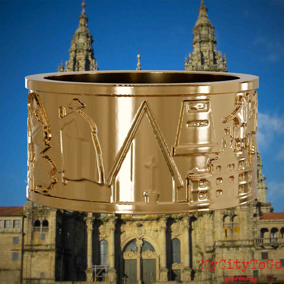 Vergoldeter Ring mit Reliefs bekannter Sehenswürdigkeiten und Wahrzeichen auf dem Jakobsweg. Den Hintergrund bildet die Kathedrale von Santiago de Compostela.