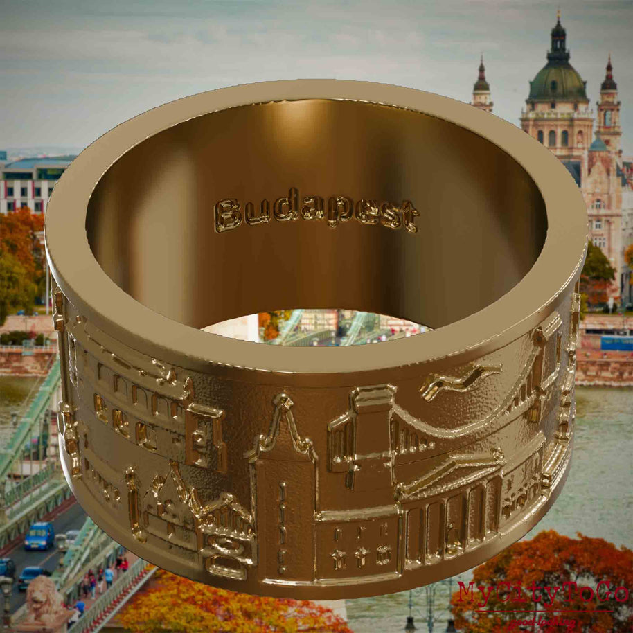 Ring aus vergoldetem Edelstahl mit Reliefs bekannter Sehenswürdigkeiten der Stadt Budapest und einer Gravur des Stadtnamens auf der Innenseite. Den Hintergrund bildet eine Ansicht der Stadt Budapest.