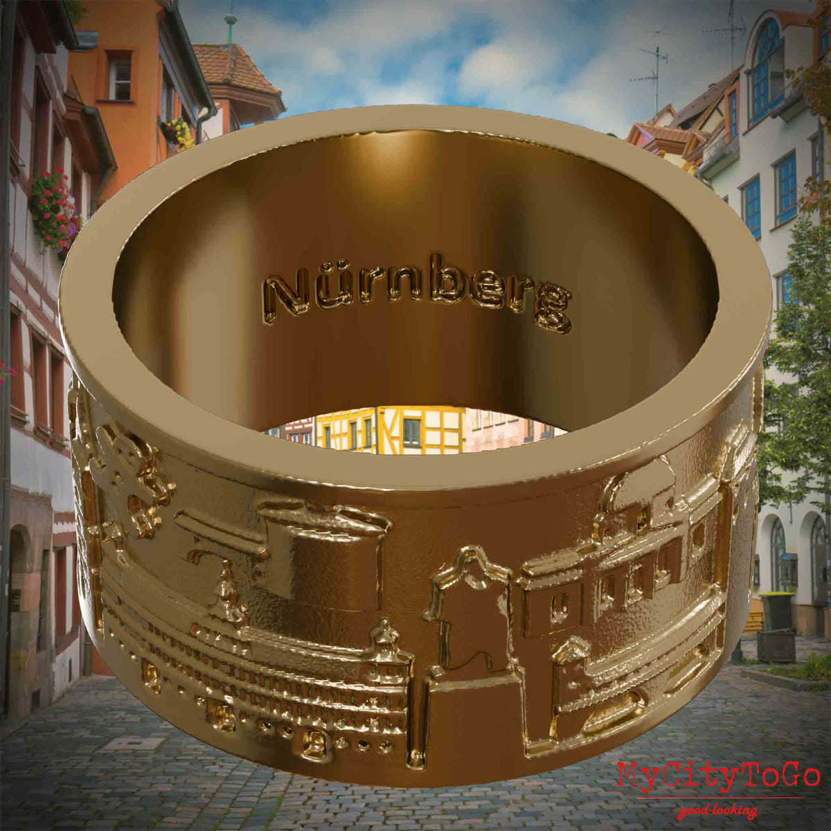 Ring aus vergoldetem Edelstahl mit Reliefs bekannter Sehenswürdigkeiten der Stadt Nuernberg und einer Gravur des Stadtnamens auf der Innenseite. Den Hintergrund bildet eine Ansicht der Stadt  Nuernberg.