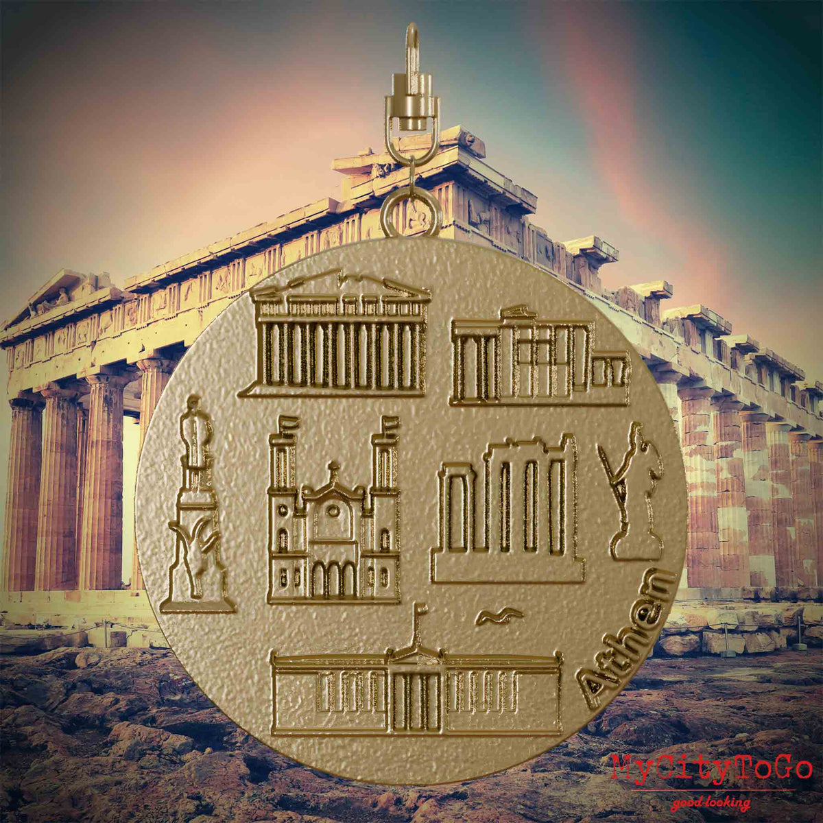 Halskette mit Drehwirbel und Vorderseite eines Schmuckanhängers aus vergoldetem Edelstahl, auf dem Reliefs bekannter Sehenswürdigkeiten der Stadt Athen abgebildet sind. Den Hintergrund bildet eine Ansicht der Stadt Athen.
