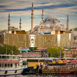 Vergoldeter Armreif mit Reliefs bekannter Sehenswürdigkeiten der Stadt Istanbul. Den Hintergrund bildet eine Ansicht der Satdt Istanbul.
