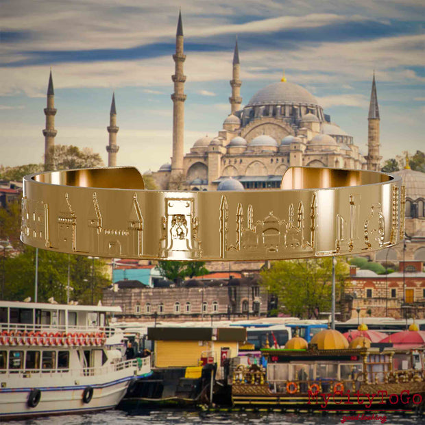 Vergoldeter Armreif mit Reliefs bekannter Sehenswürdigkeiten der Stadt Istanbul. Den Hintergrund bildet eine Ansicht der Satdt Istanbul.