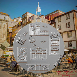 Halskette mit Drehwirbel und Rückseite eines silbernen Schmuckanhängers, auf dem Reliefs bekannter Sehenswürdigkeiten der Stadt Porto abgebildet sind. Den Hintergrund bildet eine Ansicht der Stadt Porto.
