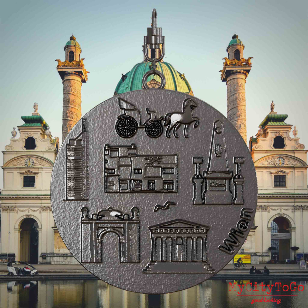 Halskette mit Drehwirbel und Vorderseite eines Schmuckanhängers aus Titan, auf dem Reliefs bekannter Sehenswürdigkeiten der Stadt Wien abgebildet sind. Den Hintergrund bildet eine Ansicht der Stadt Wien.
