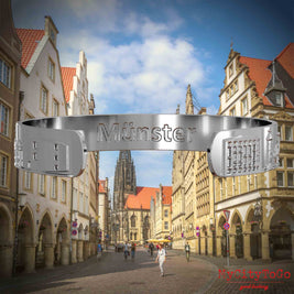 Innenseite eines silbernen Armreifs mit Reliefs bekannter Sehenswürdigkeiten der Stadt Muenster und einer Gravur des Stadtnamens. Den Hintergrund bildet eine Ansicht der Stadt Muenster.