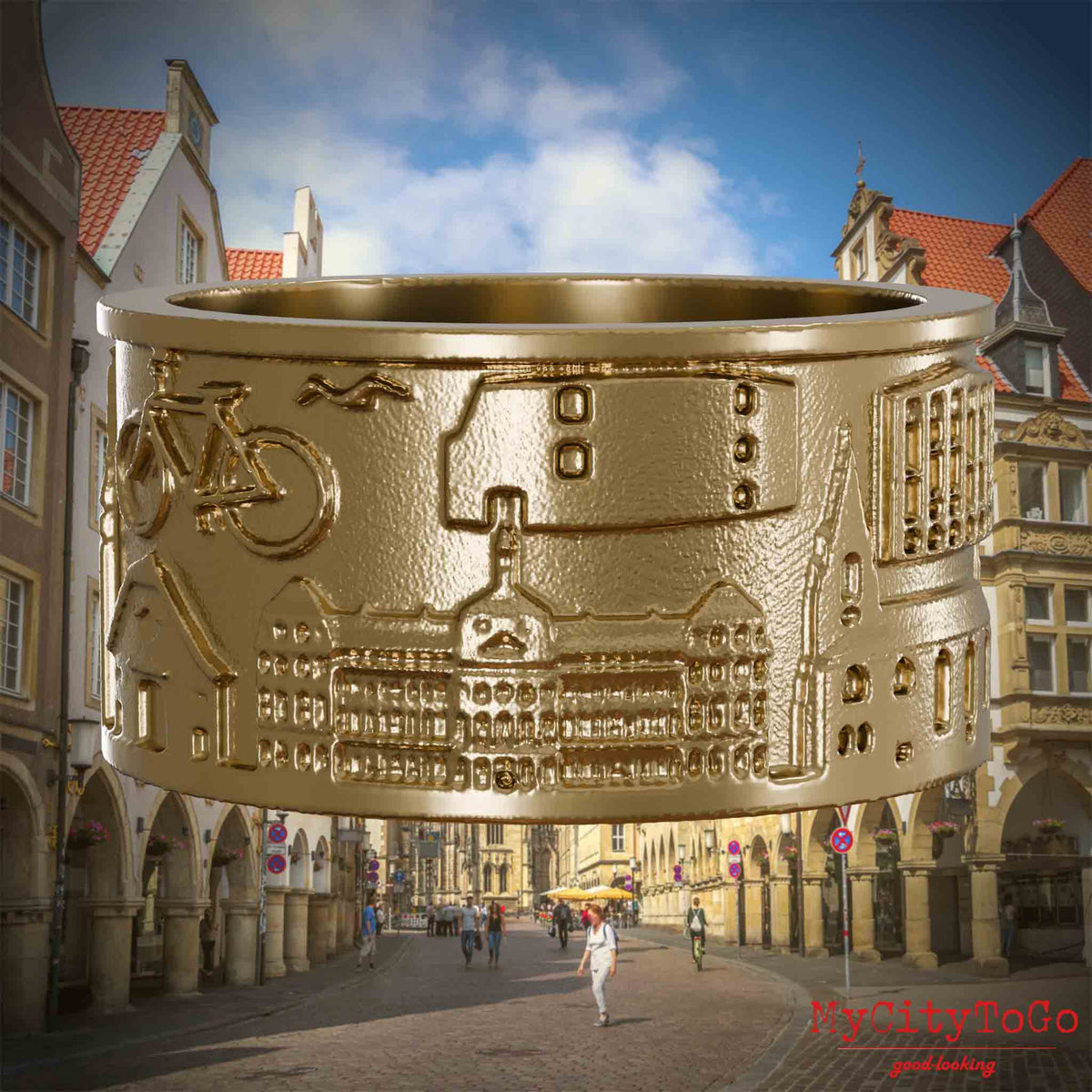 Ring aus vergoldetem Edelstahl mit Reliefs bekannter Sehenswürdigkeiten der Stadt Muenster. Den Hintergrund bildet eine Ansicht der Stadt Muenster.