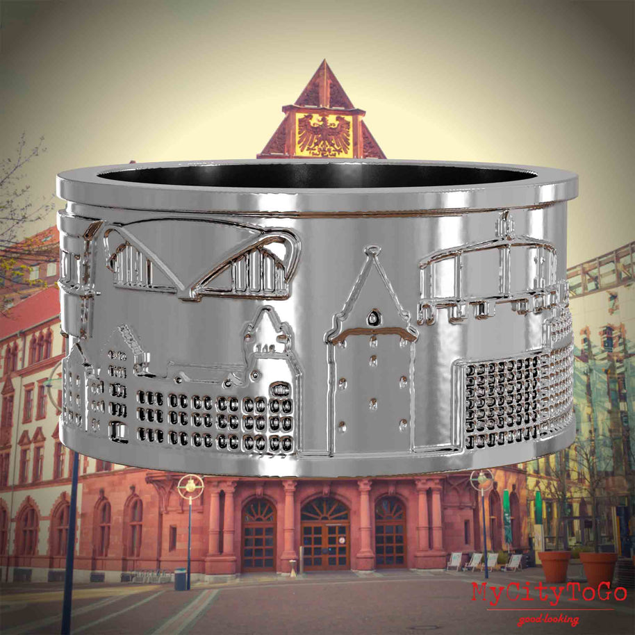 Silberner Ring mit Reliefs bekannter Sehenswürdigkeiten der Stadt Dortmund. Den Hintergrund bildet eine Ansicht der Stadt Dortmund.