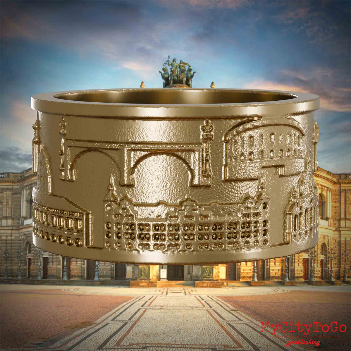 Ring aus vergoldetem Edelstahl mit Reliefs bekannter Sehenswürdigkeiten der Stadt Dresden. Den Hintergrund bildet eine Ansicht der Stadt Dresden.