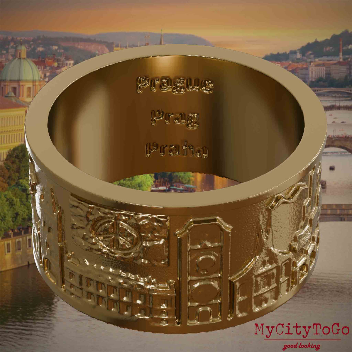 Ring aus vergoldetem Edelstahl mit Reliefs bekannter Sehenswürdigkeiten der Stadt Prag und einer Gravur des Stadtnamens auf der Innenseite. Den Hintergrund bildet eine Ansicht der Stadt Prag.