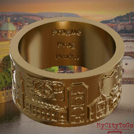 Ring aus vergoldetem Edelstahl mit Reliefs bekannter Sehenswürdigkeiten der Stadt Prag und einer Gravur des Stadtnamens auf der Innenseite. Den Hintergrund bildet eine Ansicht der Stadt Prag.