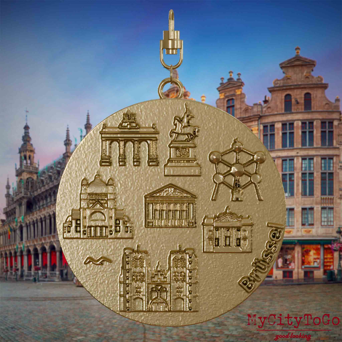 Halskette mit Drehwirbel und Rückseite eines Schmuckanhängers aus vergoldetem Edelstahl, auf dem Reliefs bekannter Sehenswürdigkeiten der Stadt Bruessel abgebildet sind. Den Hintergrund bildet eine Ansicht der Stadt Bruessel.
