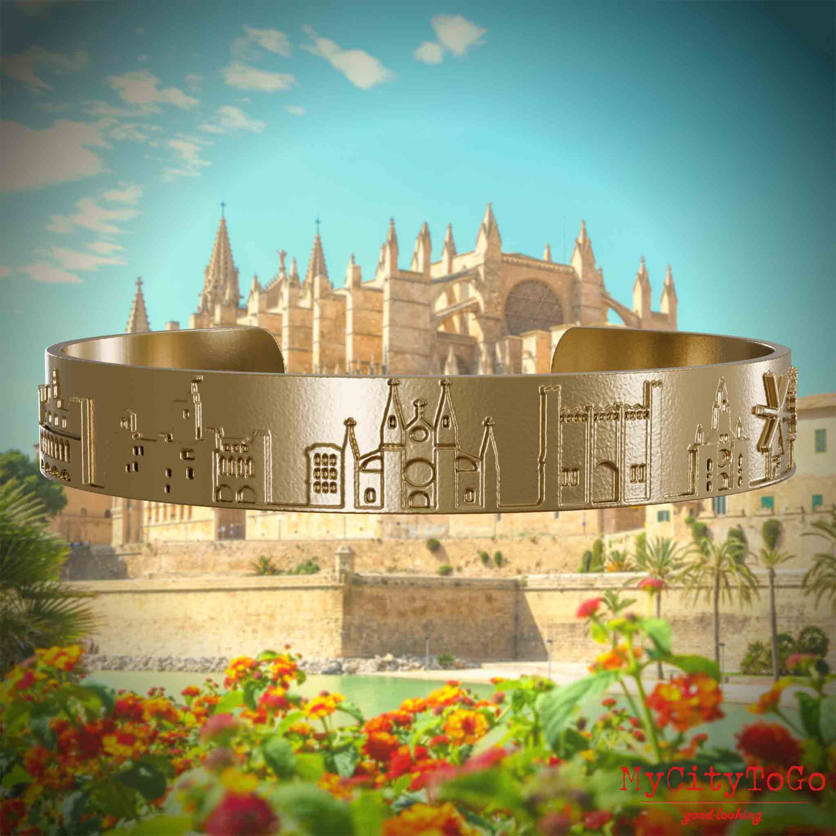 Armreif aus vergoldetem Edelstahl mit Reliefs bekannter Sehenswürdigkeiten der Stadt Palma de Mallorca. Den Hintergrund bildet eine Ansicht der Stadt Palma de Mallorca.