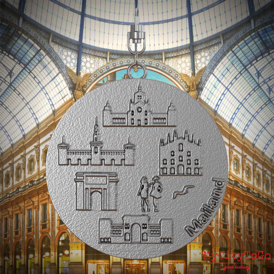 Halskette mit Drehwirbel und Rückseite eines Schmuckanhängers aus Edelstahl, auf dem Reliefs bekannter Sehenswürdigkeiten der Stadt Mailand abgebildet sind. Den Hintergrund bildet eine Ansicht der Stadt Mailand.