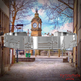 Versilberter Armreif mit Reliefs bekannter Sehenswürdigkeiten der Stadt Duesseldorf. Den Hintergrund bildet eine Ansicht der Stadt Duesseldorf.