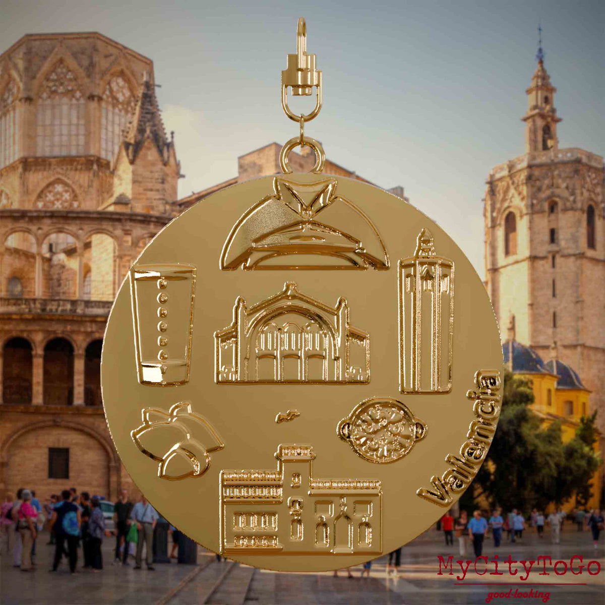 Halskette mit Drehwirbel und Vorderseite eines vergoldeten Schmuckanhängers, auf dem Reliefs bekannter Sehenswürdigkeiten der Stadt Valencia abgebildet sind. Den Hintergrund bildet eine Ansicht der Stadt Valencia.
