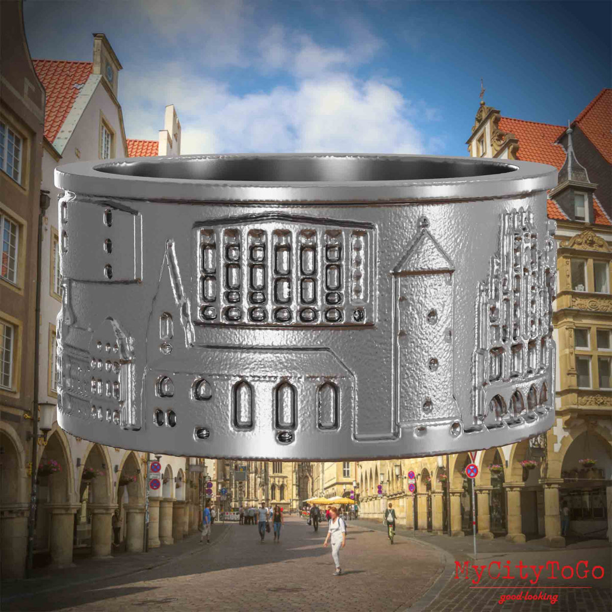 Ring aus Edelstahl mit Reliefs bekannter Sehenswürdigkeiten der Stadt Muenster. Den Hintergrund bildet eine Ansicht der Stadt Muenster.