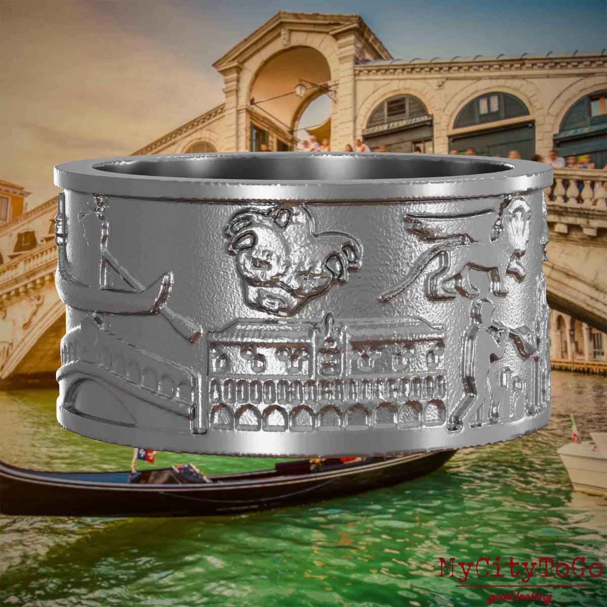 Ring aus Edelstahl mit Reliefs bekannter Sehenswürdigkeiten der Stadt Venedig. Den Hintergrund bildet eine Ansicht der Stadt Venedig.