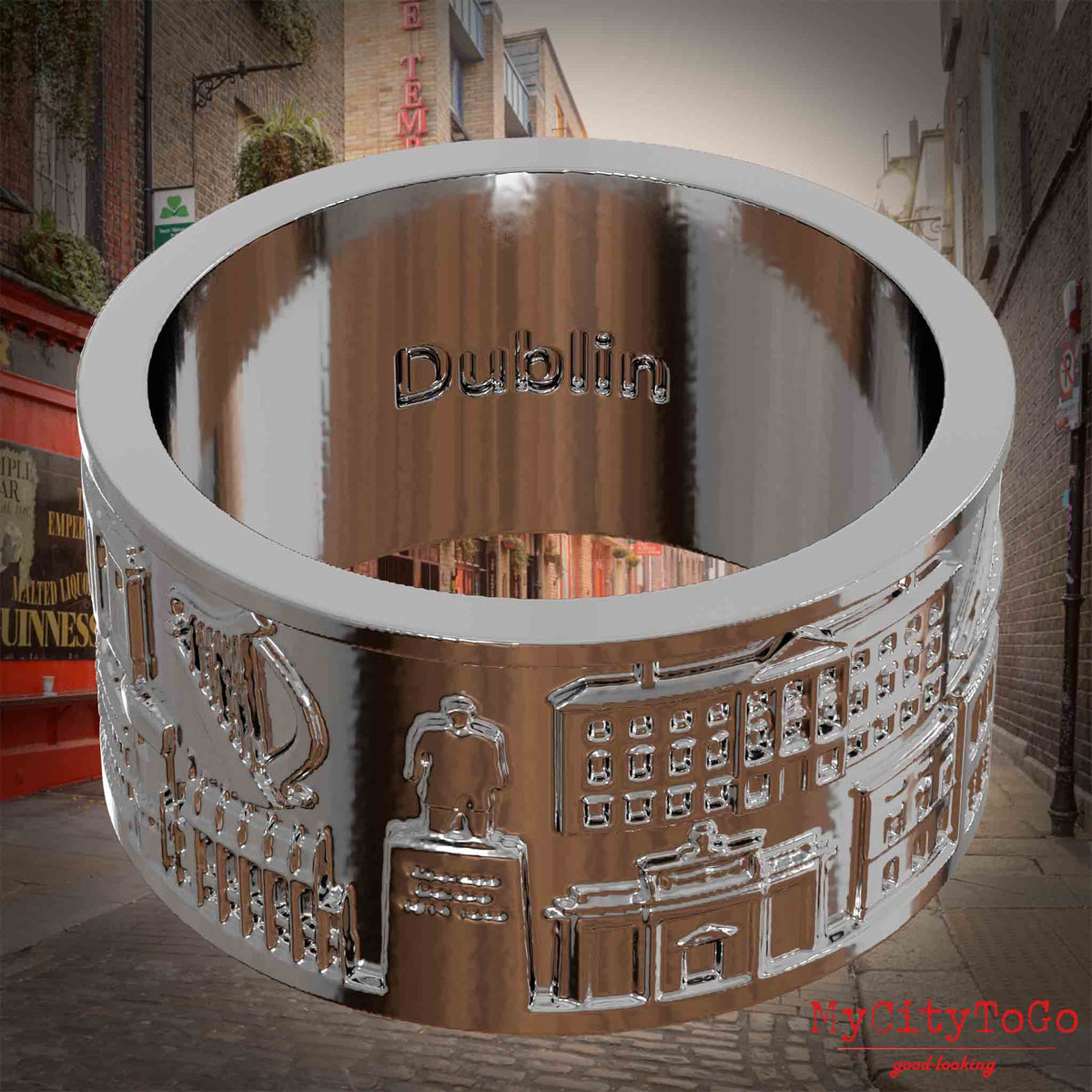 Versilberter Ring mit Reliefs bekannter Sehenswürdigkeiten der Stadt Dublin und einer Gravur des Stadtnamens auf der Innenseite. Den Hintergrund bildet eine Ansicht der Stadt Dublin.