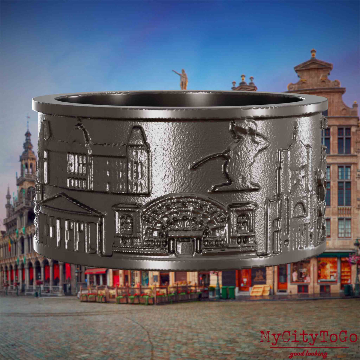 Ring aus Titan mit Reliefs bekannter Sehenswürdigkeiten der Stadt Bruessel. Den Hintergrund bildet eine Ansicht der Stadt Bruessel.