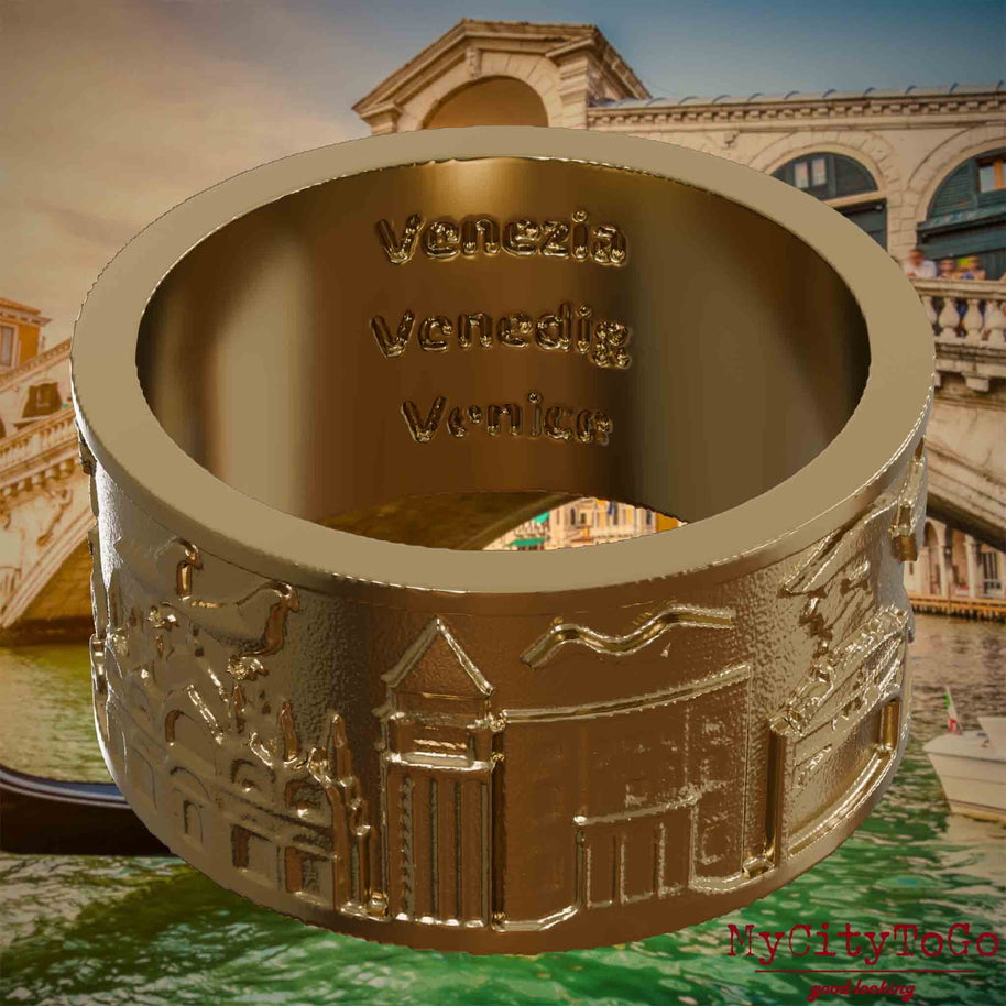 Ring aus vergoldetem Edelstahl mit Reliefs bekannter Sehenswürdigkeiten der Stadt Venedig und einer Gravur des Stadtnamens auf der Innenseite. Den Hintergrund bildet eine Ansicht der Stadt Venedig.