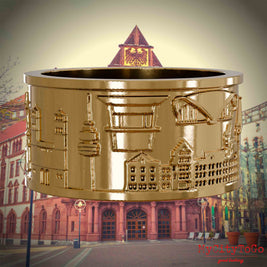 Vergoldeter Ring mit Reliefs bekannter Sehenswürdigkeiten der Stadt Dortmund. Den Hintergrund bildet eine Ansicht der Stadt Dortmund.