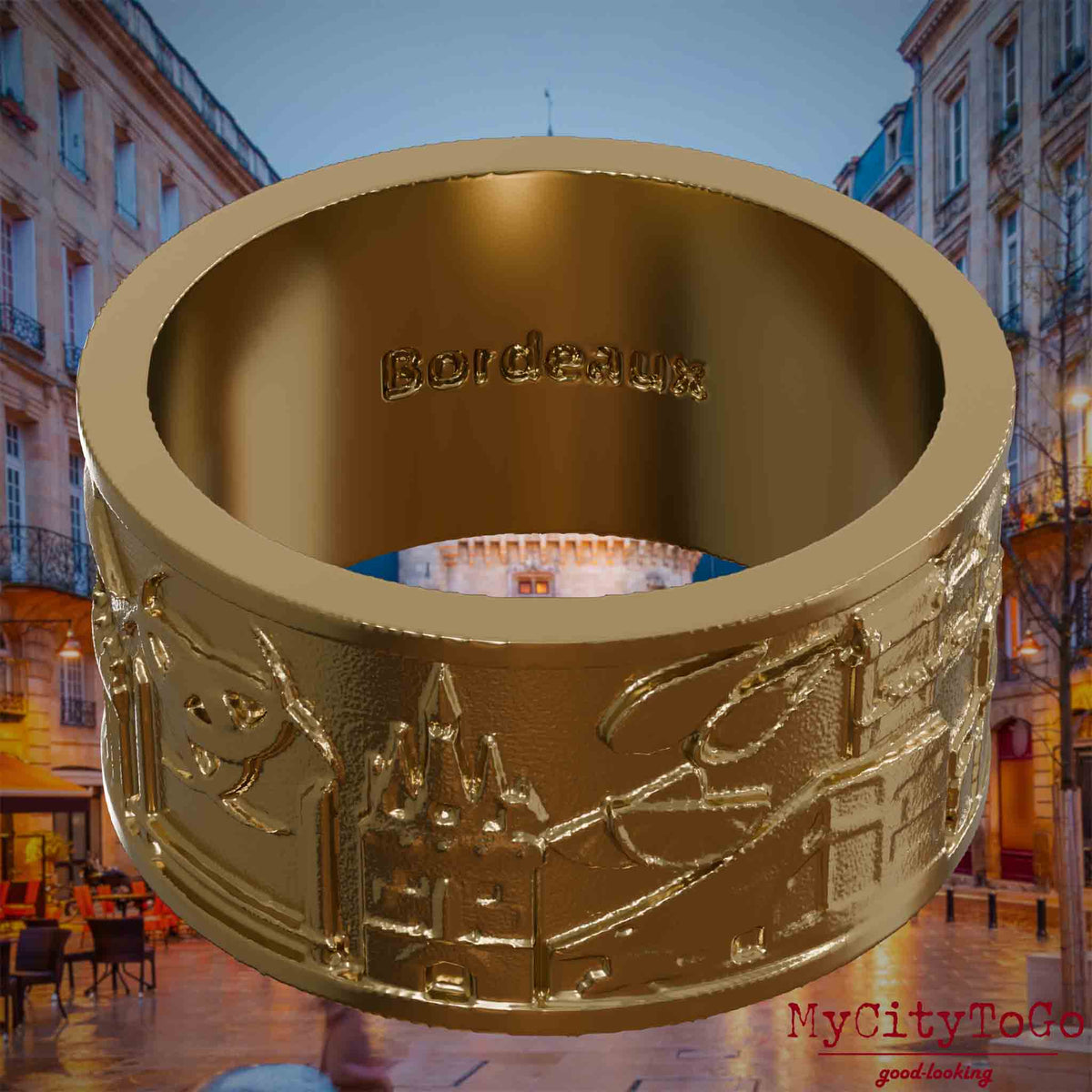Ring aus vergoldetem Edelstahl mit Reliefs bekannter Sehenswürdigkeiten der Stadt Bordeaux und einer Gravur des Stadtnamens auf der Innenseite. Den Hintergrund bildet eine Ansicht der Stadt Bordeaux.