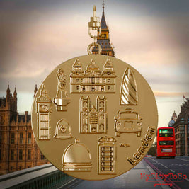 Halskette mit Drehwirbel und Rückseite eines vergoldeten Schmuckanhängers, auf dem Reliefs bekannter Sehenswürdigkeiten der Stadt London abgebildet sind. Den Hintergrund bildet eine Ansicht der Stadt London.
