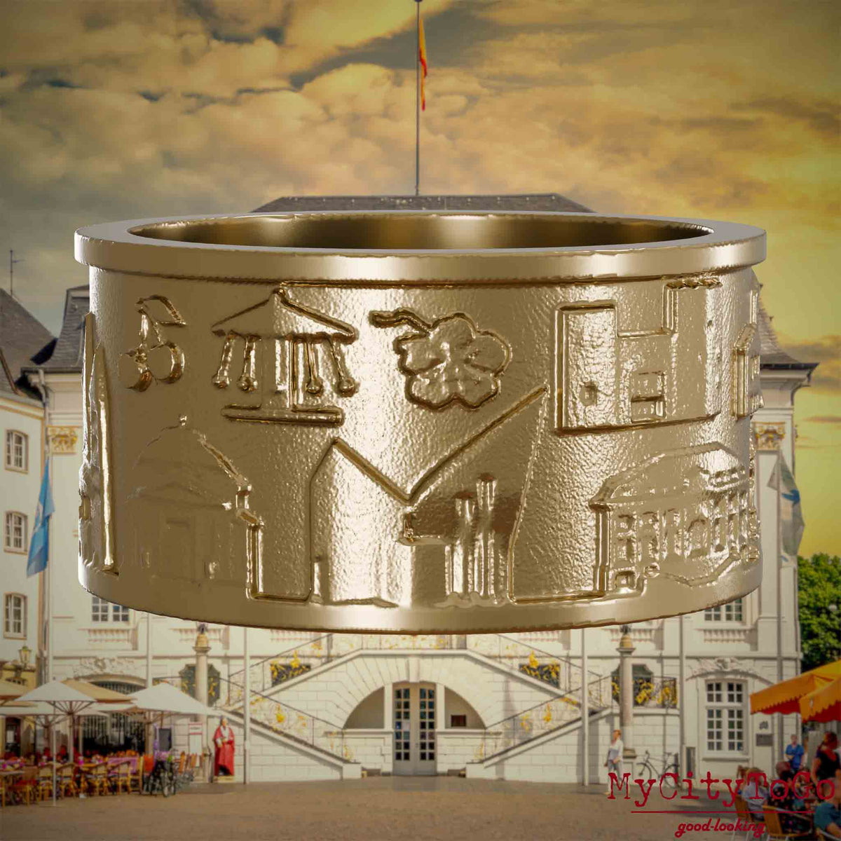 Ring aus vergoldetem Edelstahl mit Reliefs bekannter Sehenswürdigkeiten der Stadt Bonn. Den Hintergrund bildet eine Ansicht der Stadt Bonn.