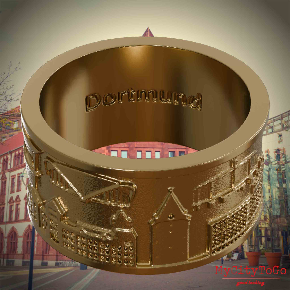 Ring aus vergoldetem Edelstahl mit Reliefs bekannter Sehenswürdigkeiten der Stadt Dortmund und einer Gravur des Stadtnamens auf der Innenseite. Den Hintergrund bildet eine Ansicht der Stadt Dortmund.