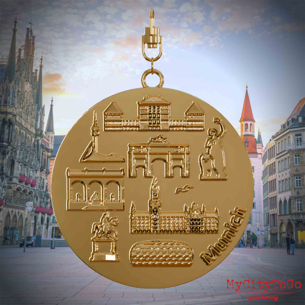 Halskette mit Drehwirbel und Rückseite eines vergoldeten Schmuckanhängers, auf dem Reliefs bekannter Sehenswürdigkeiten der Stadt Muenchen abgebildet sind. Den Hintergrund bildet eine Ansicht der Stadt Muenchen.