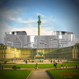 Versilberter Armreif mit Reliefs bekannter Sehenswürdigkeiten der Stadt Stuttgart. Den Hintergrund bildet eine Ansicht der Stadt Stuttgart.