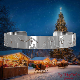 Silberner Armreif mit Reliefs weihnachtlicher Motive. Den Hintergrund bildet ein naechtliches Weihnachtsmotiv.