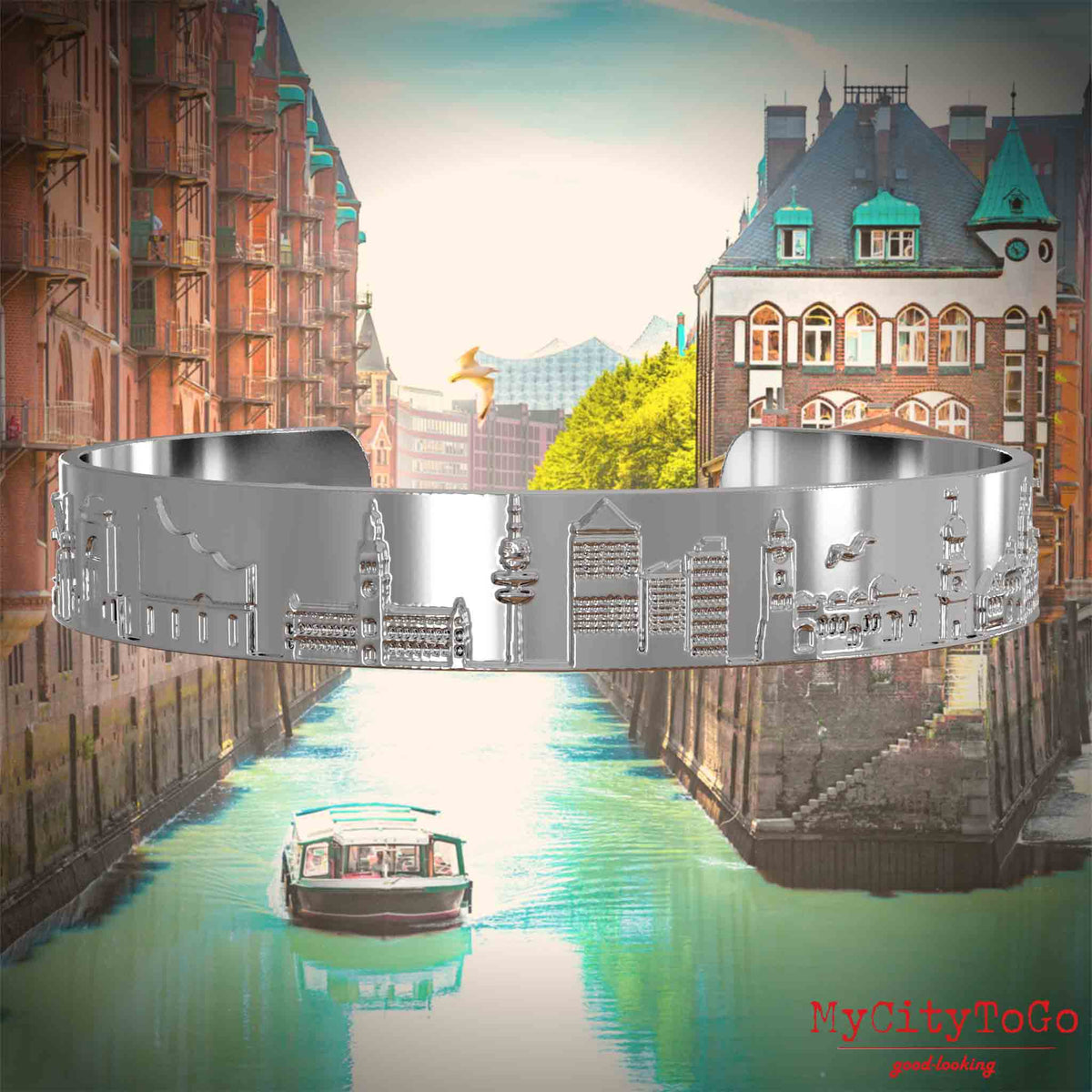 Versilberter Armreif mit Reliefs bekannter Sehenswürdigkeiten der Stadt Hamburg. Den Hintergrund bildet eine Ansicht der Stadt Hamburg.