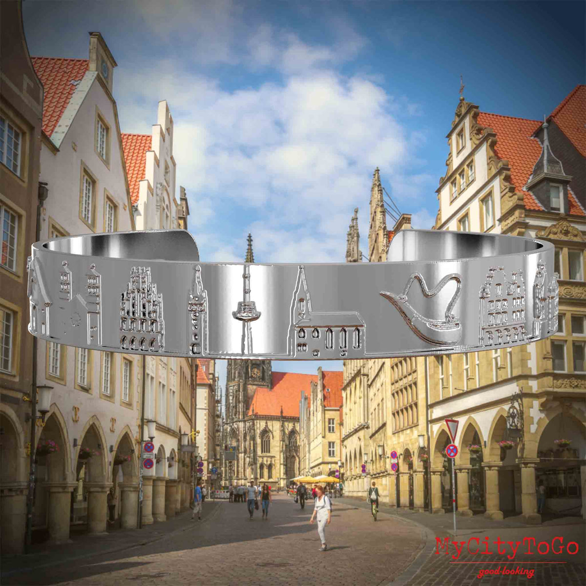 Versilberter Armreif mit Reliefs bekannter Sehenswürdigkeiten der Stadt Muenster. Den Hintergrund bildet eine Ansicht der Stadt Muenster.