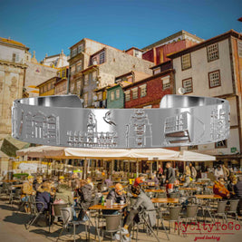 Versilberter Armreif mit Reliefs bekannter Sehenswürdigkeiten der Stadt Porto. Den Hintergrund bildet eine Ansicht der Stadt Porto.