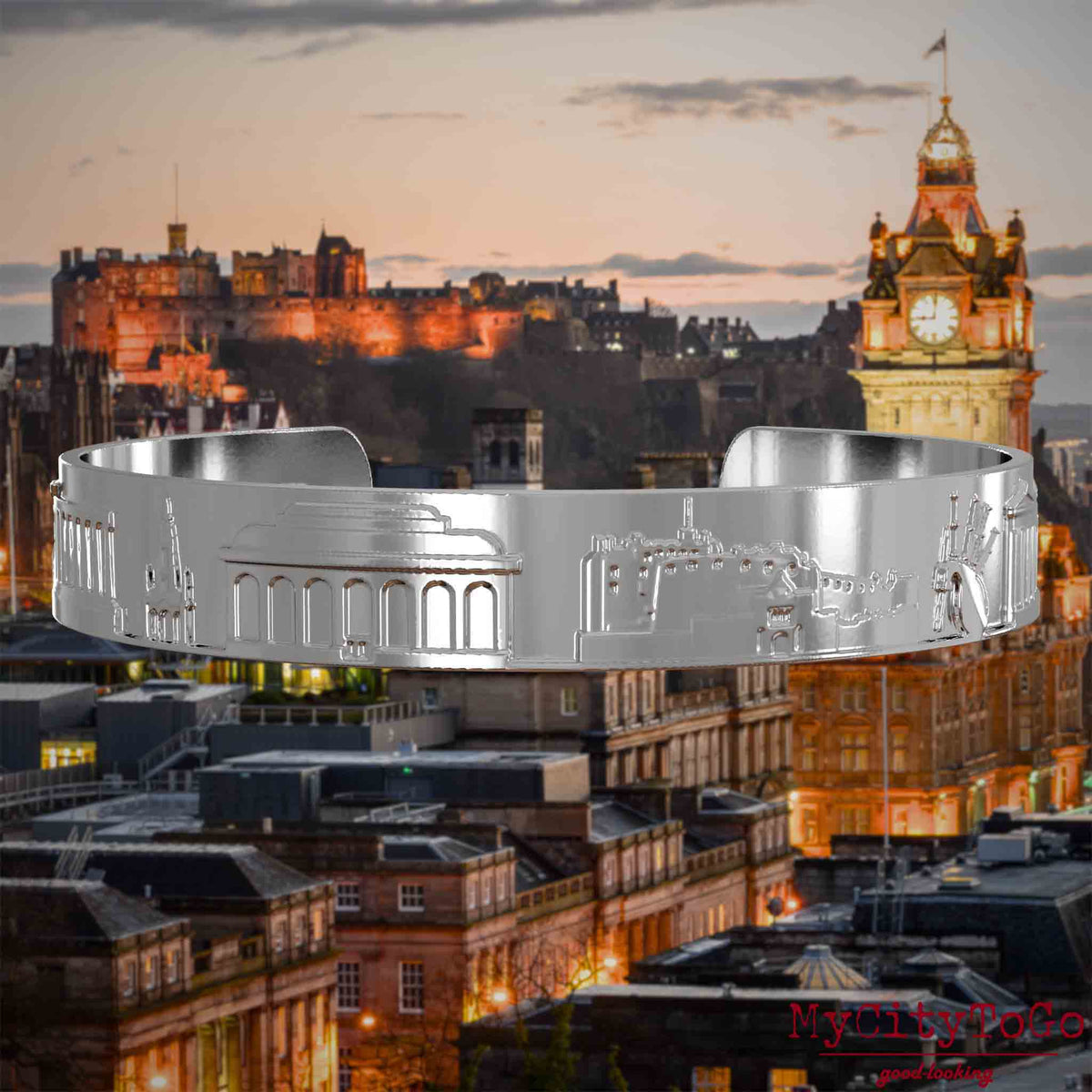 Versilberter Armreif mit Reliefs bekannter Sehenswürdigkeiten der Stadt Edinburgh. Den Hintergrund bildet eine Ansicht der Stadt Edinburgh.