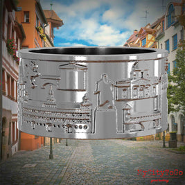 Silberner Ring mit Reliefs bekannter Sehenswürdigkeiten der Stadt Nuernberg. Den Hintergrund bildet eine Ansicht der Stadt  Nuernberg.