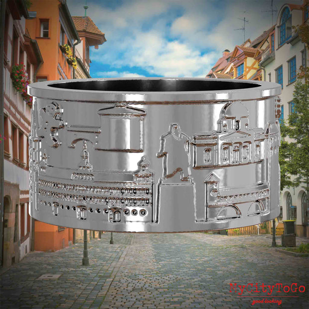 Silberner Ring mit Reliefs bekannter Sehenswürdigkeiten der Stadt Nuernberg. Den Hintergrund bildet eine Ansicht der Stadt  Nuernberg.