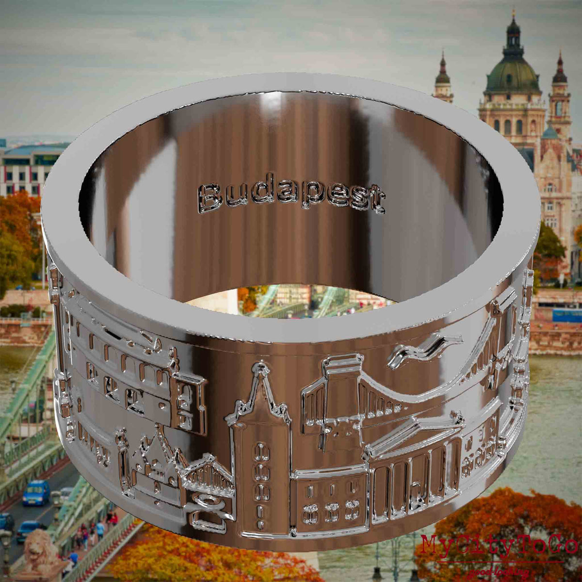 Versilberter Ring mit Reliefs bekannter Sehenswürdigkeiten der Stadt Budapest und einer Gravur des Stadtnamens auf der Innenseite. Den Hintergrund bildet eine Ansicht der Stadt Budapest.