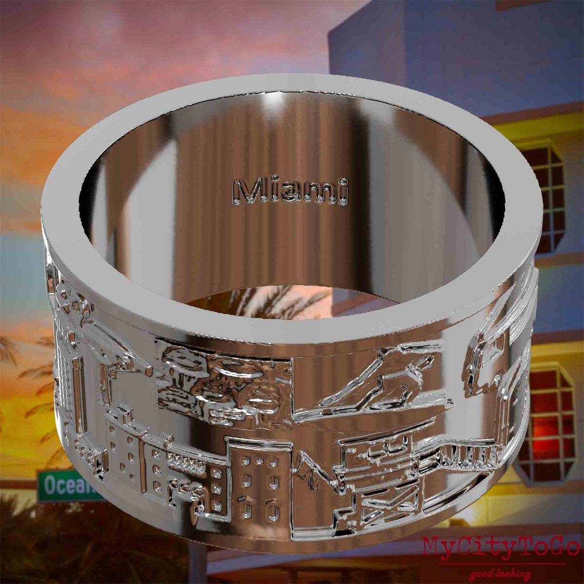 Versilberter Ring mit Reliefs bekannter Sehenswürdigkeiten der Stadt Miami und einer Gravur des Stadtnamens auf der Innenseite. Den Hintergrund bildet eine Ansicht der Stadt Miami.
