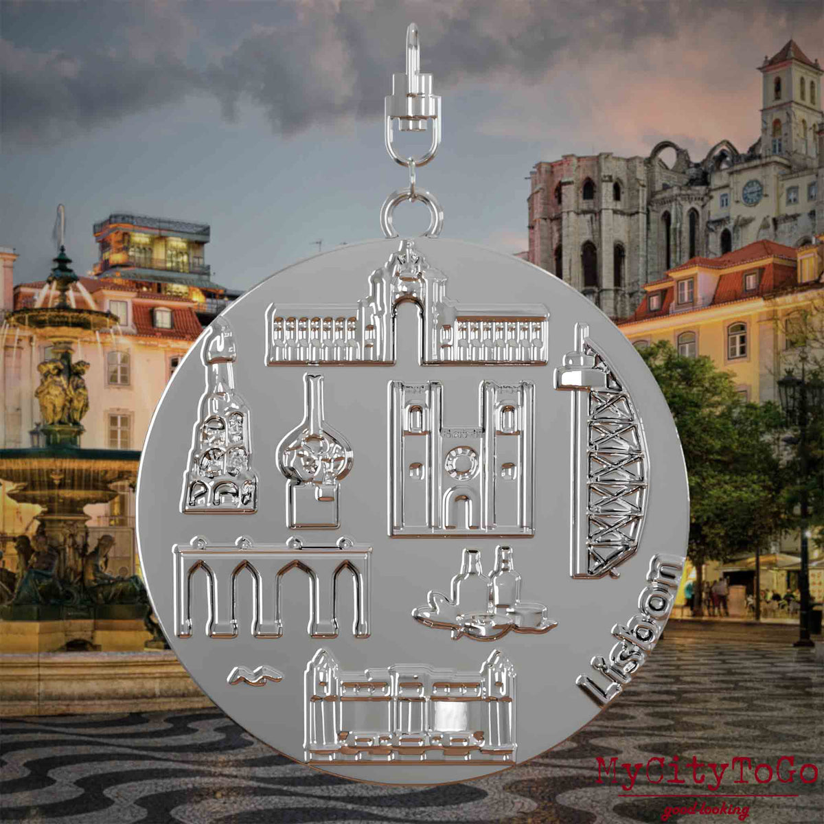 Halskette mit Drehwirbel und Rückseite eines silbernen Schmuckanhängers, auf dem Reliefs bekannter Sehenswürdigkeiten der Stadt Lissabon abgebildet sind. Den Hintergrund bildet eine Ansicht der Stadt Lissabon.
