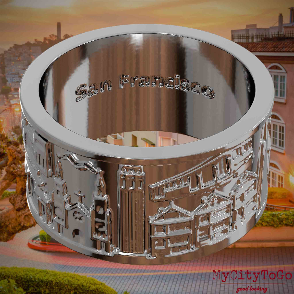 Versilberter Ring mit Reliefs bekannter Sehenswürdigkeiten der Stadt San Francisco und einer Gravur des Stadtnamens auf der Innenseite. Den Hintergrund bildet eine Ansicht der Stadt San Francisco.