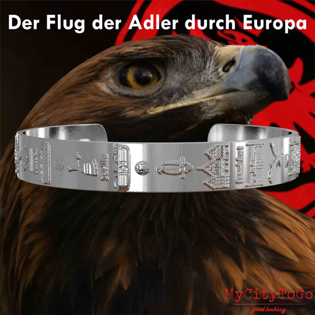 Versilberter Armreif mit Reliefs der Stadien und Sehenswürdigkeiten der Spielorte während der Europa-League-Saison 21/22 von Frankfurt mit einem Adlerkopf als Hintergrund