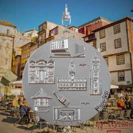 Halskette mit Drehwirbel und Vorderseite eines silbernen Schmuckanhängers, auf dem Reliefs bekannter Sehenswürdigkeiten der Stadt Porto abgebildet sind. Den Hintergrund bildet eine Ansicht der Stadt Porto.
